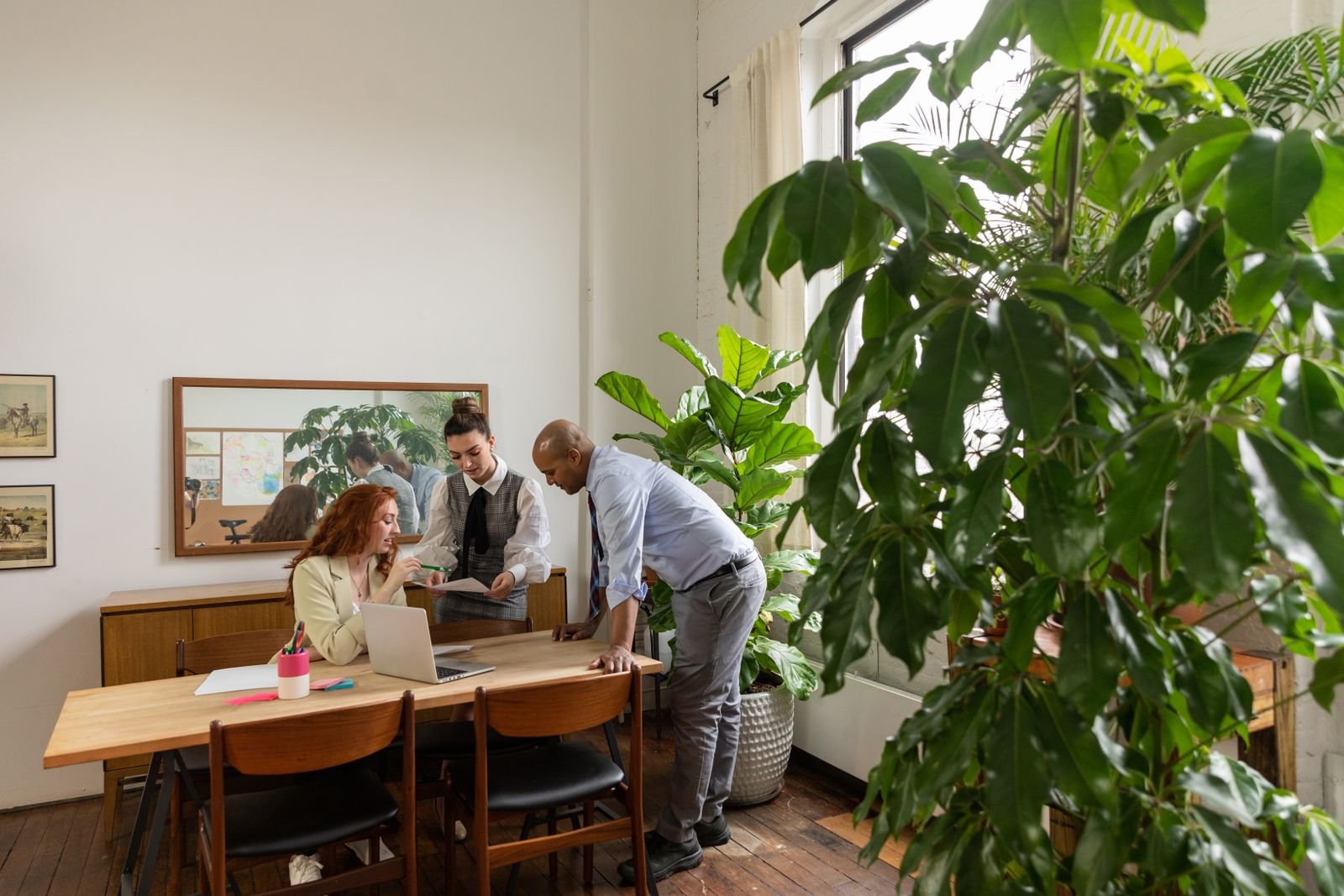Team collaborating in a modern office filled with greenery